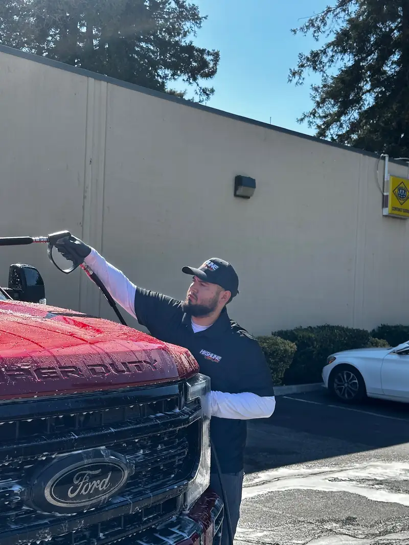 HighLine AutoCare pressure washing a Ford Super Duty at a customer's home
