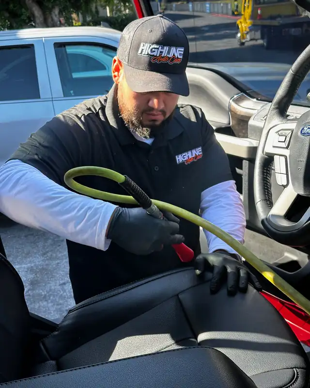 Highline Auto Care technician steam cleaning the interior of a Ford Super Duty in San Jose